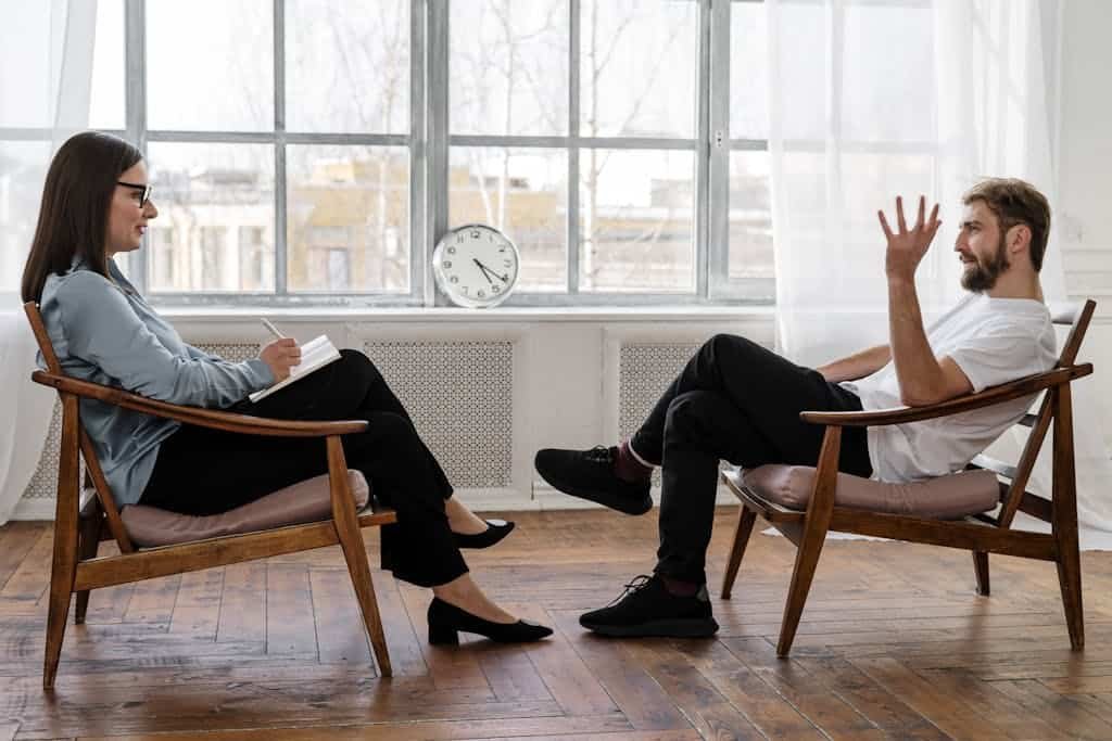Photo by cottonbro studio Person in Black Pants and Black Shoes Sitting on Brown Wooden Chair